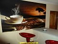 Fototapeta na stene Káva krásne harmonizuje s bielym nábytkom v kuchyni a s červenými barovými stoličkami 